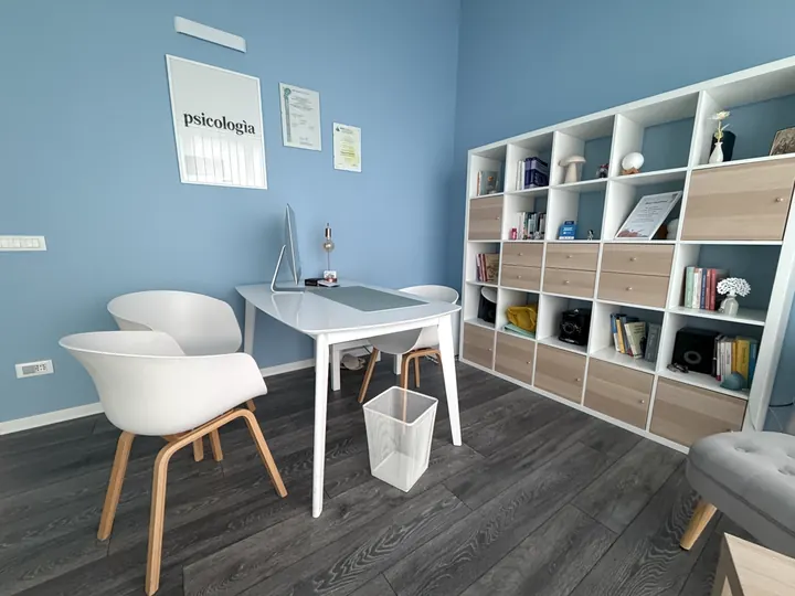 Scrivania, sedie e libreria nella stanza azzurra dello studio a Roma Eur