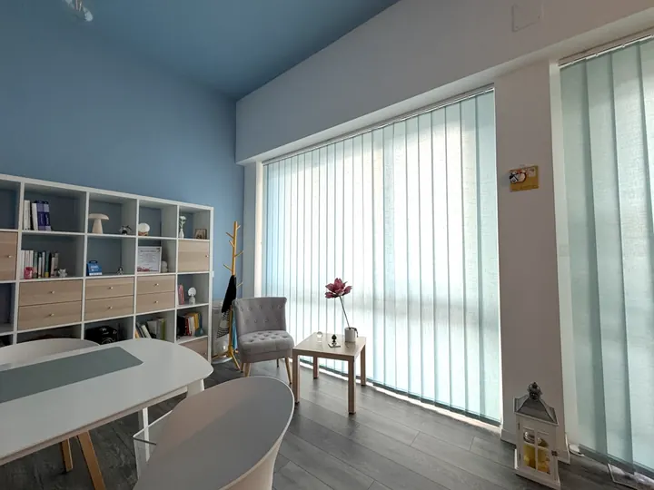 Seconda stanza dello studio, con scrivania, poltroncina grigia e grande vetrata luminosa