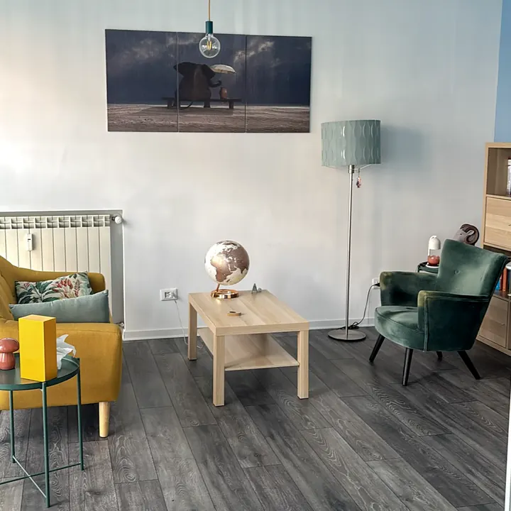 Angolo dello studio con le poltrone per il colloquio e una lampada da terra